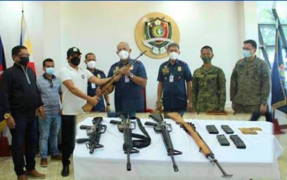 <p><strong>DISBANDED FOR PEACE.</strong> PRO-BARMM director Brig. Gen. Eden Ugale accepts the firearms from Shariff Aguak Mayor Marop Ampatuan following the surrender of his father, Datu Akmad Ampatuan (extreme left), ex-vice mayor of Shariff Aguak town and the leader of the surrendering private armed group, during surrender rites at Camp S.K. Pendatun in Parang, Maguindanao on Monday (July 5, 2021). The group also yielded assorted high-powered firearms during their surrender. <em>(Photo courtesy of PRO-BARMM)</em></p>