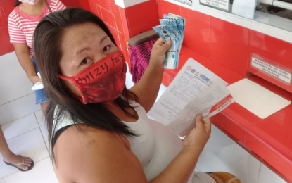<p><strong>CASH AID.</strong> A beneficiary claims her cash aid at a payout center accredited by StarPay Corporation in this 2020 photo. The financial service provider belied the allegation of Senator Manny Pacquiao that its distribution of the Social Amelioration Program assistance is anomalous. <em>(Photo courtesy of StarPay Facebook)</em></p>