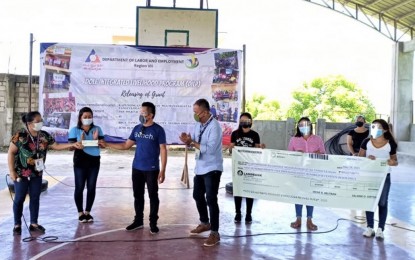 <div><strong>DOLE AID</strong>. Members of Kapunongan sa Gagmay nga Mananagat sa Tangculogan (KAGAMATA), an association of fisherfolk based in Bais City, Negros Oriental, receive from the Department of Labor and Employment a check of almost PHP1 million as capital for their seaweed farming business. The group will sell dried seaweed to local traders and fresh seaweed at markets in Bais City and nearby towns in the province. <em>(Photo courtesy of DOLE-7) </em></div>
