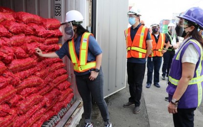 <p><strong>SEIZED</strong>. SBMA Chairman and Administrator Wilma Eisma (left), Port of Subic Customs Collector Marites Martin (right), and DTI Assistant Secretary Ronnel Abrenica (center) inspect on Monday (July 12, 2021) one of the 12 container vans filled with misdeclared onions. The cargoes arrived in Subic from China and were consigned to two port users. <em>(Photo courtesy of SBMA)</em></p>