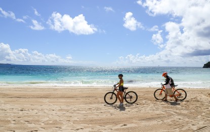 <p><strong>BY THE SEASHORE.</strong> Cyclists passing by Boracay's world-famous white beach. Boracay is among the country's destinations that implement a strict entry protocol for tourists, including securing QR codes to easily access services while on the island. <em>(Photo by DOT/Denison Manuel)</em></p>