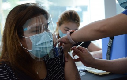 <p><strong>FOR PROTECTION.</strong> An overseas Filipino worker gets vaccinated against Covid-19 in Taguig City. The Philippine Consulate General is set to present its proposal to Hong Kong authorities to recognize the country's international vaccine certificate. <em>(PNA photo by Avito C. Dalan)</em></p>