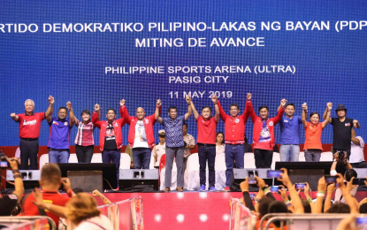 <p><strong>NO INTENTION</strong>. President Rodrigo Roa Duterte raises the hands of the Partido Demokratiko Pilipino-Lakas ng Bayan (PDP-Laban) senatorial and guest candidates during the ruling party's ‘miting de avance’ in Pasig City on May 11, 2019. Presidential Spokesperson Harry Roque on Thursday (July 15, 2021) said he has no intention to insult PDP-Laban when he shrugged off the threats to expel Duterte as the party’s chairperson. <em>(Presidential photo)</em></p>
