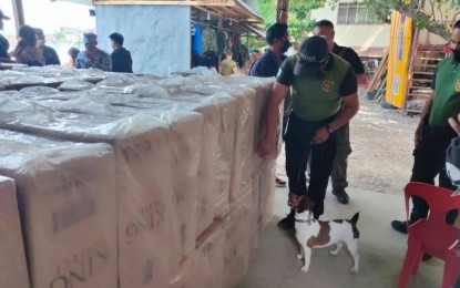 <p><strong>SMUGGLED CIGARETTES.</strong> A K9 unit of the Philippine Drug Enforcement Agency (PDEA) conducts inspection and paneling on the master cases of confiscated smuggled cigarettes for possible presence of illegal drugs. The smuggled cigarettes worth PHP3.5 million were seized by the joint police and Bureau of Customs (BOC) operatives on Thursday (July 15, 2021) near Manalipa Island in Zamboanga City.<em> (Photo lifted from the Facebook page of the 2nd Zamboanga City Mobile Force Company)</em></p>