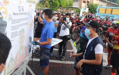 <p><strong>PEACE COVENANT</strong>. Participants of the "Bike for Justice and Peace" in Aurora province on Saturday (July 17, 2021) sign a peace covenant to show support in condemning the acts of the communist terrorist groups. The activity was a nationwide civil-inspired biking event to call for true and lasting peace in communities.<em> (Photo by Army's 91IB)</em></p>