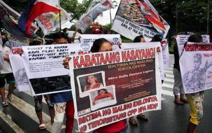 <p><strong>WASTED YOUTH.</strong> Members of the League of Parents of the Philippines display photos of University of the Philippines graduates who joined the armed struggle during a rally at the Diliman campus in Quezon City on Monday (July 19, 2021). The group warned the school administration to be on the lookout for leftist groups that recruit students to join the New People’s Army. <em>(PNA photo by Joey Razon)</em></p>