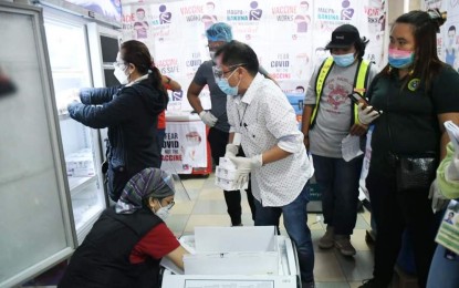 <p><strong>VACCINE STORAGE</strong>. Personnel of Bacolod City Health Office led by officer-in-charge Dr. Edwin Miraflor Jr. (center) store the newly-arrived vaccines in the cold room located beside the Government Center on Monday (July 19, 2021). Some 51,040 doses arrived, including 30,000 doses of Johnson & Johnson’s (J&J) single-dose Janssen; 18,700 doses of AstraZeneca; and 2,340 doses of Pfizer-BioNTech jabs. <em>(Photo courtesy of Bacolod City PIO)</em></p>