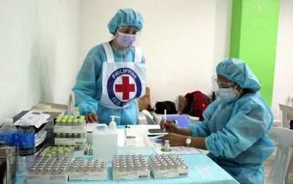 <p><strong>SECOND DOSES.</strong> Nurse Myrna Bernardino (right) and a Philippine Red Cross volunteer prepare Covid-19 vaccines to be administered as second doses at Central Mall Dasmariñas in Cavite on July 16, 2021. Different priority groups received free jabs. <em>(PNA photo by Gil Calinga)</em></p>