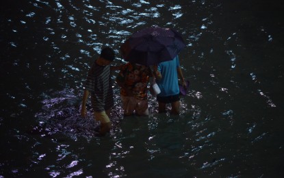 <p><strong>DEEP FLOODS.</strong> Commuters wade through deep floodwaters caused by non-stop heavy rains along Alabang-Zapote Road in Las Piñas City Thursday (July 22, 2021) evening. The Department of Health noted a 13-percent increase in leptospirosis cases this year compared to the same period in 2020.<em> (PNA photo by Avito C. Dalan) </em></p>