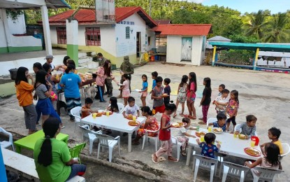 <p><strong>FEEDING PROGRAM.</strong> The Philippine Army sponsors a feeding program initiated by the Sangguniang Kabataan of Sitio Cabas-An in Aroroy, Masbate in this July 2021 photo. Task Force Zero Hunger likewise enjoins the public and private sector to help the government address nutrition gap among children through the ‘Kain Tayo Pilipinas’ movement. <em>(Photo courtesy of SK Cabas-An Facebook)</em></p>