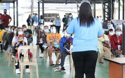 <p><strong>CAMSUR-BOUND.</strong> Beneficiaries of the Balik Probinsya, Bagong Pag-asa program listen to the pre-departure briefing at the BP2 depot in Quezon City on Thursday (July 22, 2021). Eight families, composed of 24 individuals, will go home to Camarines Sur all expenses paid and with financial and livelihood assistance. <em>(PNA photo by Robert Alfiler)</em></p>