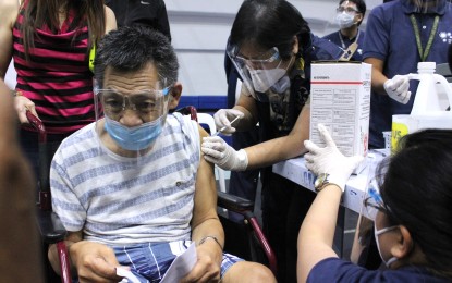 <p><strong>SINGLE SHOT.</strong> Department of Health (DOH) Regional Director Gloria Balboa administers the single-dose Johnson&Johnson vaccine to Ramon Rustia, 61, during the vaccination for senior citizens and persons with comorbidities at the Pasig Sports Center in Pasig City on Thursday (July 22, 2021). The country has recorded a total of 472,356 doses of Covid-19 vaccine administered on Thursday, the highest daily so far since the vaccination program started in March. <em>(PNA photo by Joey O. Razon) </em></p>