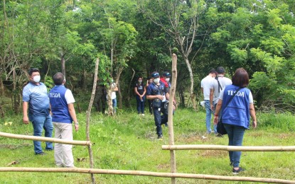 <p><strong>INSURGENCY-CLEARED VILLAGE</strong>. E.B. Magalona Mayor Marvin Malacon (left) and officials of the Technical Education and Skills Development Authority (TESDA) visit an area in Barangay Canlusong during the launch of the “Tulong-tulong para sa Pag-asenso ng Barangay Canlusong” program on July 14, 2021. Some 25 village residents are beneficiaries of the training for Organic Agriculture Production NC II with the TESDA.<em> (Photo courtesy of TESDA-Negros Occidental)</em></p>