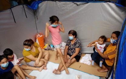 <p><strong>SAFER GROUNDS.</strong> A family stays inside an evacuation tent at the Nangka Elementary School in Marikina City on Saturday (July 24, 2021). About 3,400 families sought shelter in 29 evacuation centers in the city as monsoon rains caused the Marikina River to swell. <em>(Photo courtesy of Mike Rogas, Radyo Pilipinas)</em></p>