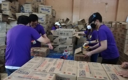 <p><strong>FOOD PACKS</strong>. The Department of Social Welfare and Development in the Cordillera Region has 30,000 family food packs ready to augment the supply of local government units for people affected by the southwest monsoon enhanced by Typhoon Fabian. An undated photo shows volunteers readying food packs at the DSWD warehouse in La Trinidad, Benguet. <em>(PNA file photo by Liza T. Agoot)</em></p>