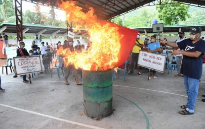 <p><strong>CONDEMNATION</strong>. A group of residents of Barangay Caliling, Cauayan town in Negros Occidental burns the CPP-NPA flag after pledging allegiance to the government and declaring the communist-terrorist groups as persona non grata in rites held at the village gymnasium on Saturday (July 25, 2021). The activity was facilitated by the Philippine Army’s 14th Civil-Military Operations Battalion Community Support Program Team. <em>(Photo courtesy of 14th CMO Battalion)</em></p>