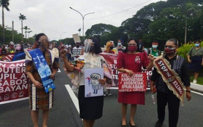 <p><strong>PROTEST RALLY.</strong> Some protesters wear Filipiniana dress and barong as they hold a rally along Commonwealth Avenue near UP Diliman on Monday (July 26, 2021). They were told to observe health protocols as failure to do is enough reason to stop the rally.<em> (Photo courtesy of PTV-4)</em></p>