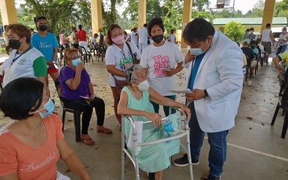 <p><strong>MOBILE VACCINATION.</strong> Legazpi City Health Office (CHO) chief Dr. Fulbert Gillego interviews an elderly woman before the administration of a Covid-19 vaccine at the covered court of Barangay Homapon in Legazpi City on Tuesday (July 27, 2021). He said the mobile vaccination program aims to serve senior citizens and persons with disabilities, especially those in far-flung villages.<em> (Photo by Emmanuel Solis)</em></p>