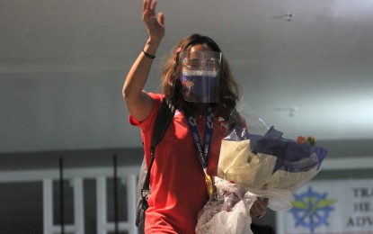 <p><strong>1ST OLYMPIC GOLD MEDALIST.</strong> Weightlifter Hidilyn Diaz, the country’s first-ever Olympic gold winner, waves to well-wishers upon arrival at the Ninoy Aquino International Airport Terminal 2 in Pasay City on Wednesday (July 28, 2021). The Zamboanga City native ended the country’s 97-year wait for a top podium finish. <em>(PNA photo by Avito C. Dalan)</em></p>