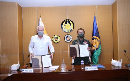 <p><strong>SUPPORT FOR TROOPS.</strong> AFP chief Gen. Cirilito Sobejana (right) and Ayala Corporation president and chief executive officer Fernando Zobel de Ayala (left) show a copy of the memorandum of understanding for the 'Saludo Sa Serbisyo' program at Camp Aguinaldo, Quezon City on Thursday (July 29, 2021). It is a needs-based program that gives uniformed personnel expanded access to the Ayala Group of Companies' products and services, enabling them to pick the best support they need in every key milestone of their lives. <em>(Photo courtesy of AFP Public Affairs Office)</em></p>