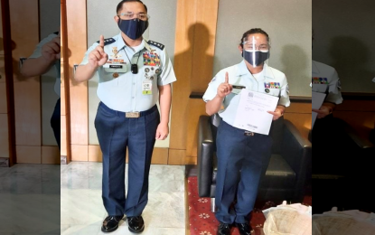 <p><strong>PROMOTED.</strong> Philippine Air Force (PAF) chief, Lt. Gen. Allen Paredes (left) poses with newly promoted Staff Sgt. Hidilyn Diaz at the NAIA Terminal 2 shortly after her arrival on Wednesday (July 28, 2021). Diaz was promoted to staff sergeant in honor of her historic gold medal win at the women's 55-kg. weightlifting event at the Tokyo Olympics. (Photo courtesy of Air Force Public Affairs Office)</p>