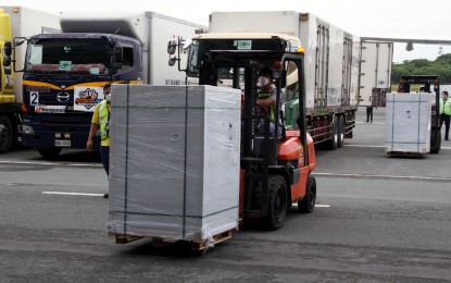 <p><strong>LIFE-SAVERS.</strong> A forklift operator loads government-procured Sinovac vaccines into refrigerated trucks at the Ninoy Aquino International Airport Terminal 3 in Pasay City on Friday (July 30, 2021). The bulk of the China-made jabs will be deployed to the National Capital Region which is the most vulnerable to Covid-19 infections. <em>(PNA photo by Jess M. Escaros Jr.)</em></p>