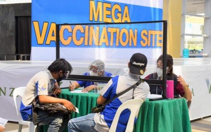 <p><strong>NEW VAX SITE</strong>. Health workers interview two A4 category or essential workers before their inoculation against coronavirus disease 2019 (Covid-19) on Tuesday (Aug. 3, 2021) at the newly-opened mega vaccination site inside KCC Veranza Mall in General Santos City. It is the second mall-based mega vaccination center opened by the local government.<em>(Photo courtesy of the city government)</em></p>
