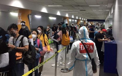 <p><strong>BACK HOME.</strong> A DFA officer oversees the arrival of repatriates from the United Arab Emirates in this undated photo. As of July 31, over 3,500 distressed Filipinos were sent home using the DFA's Assistance to Nationals Fund. <em>(Photo courtesy of DFA)</em></p>