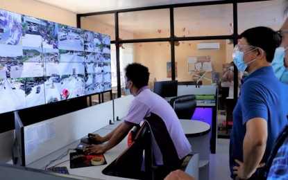 <p><strong>EYE ON THE STREETS</strong>. Tabuk City Mayor Darwin Estranero (in blue shirt) looks at the monitoring operation of the command center which has been equipped with computer application using facial recognition system as well as a vehicle plate recognition and speed sensor. The command center is coupled with high-definition closed-circuit television (CCTV) cameras mounted in strategic areas in the city. (<em>Photo courtesy of Tabuk City PIO</em>) </p>
