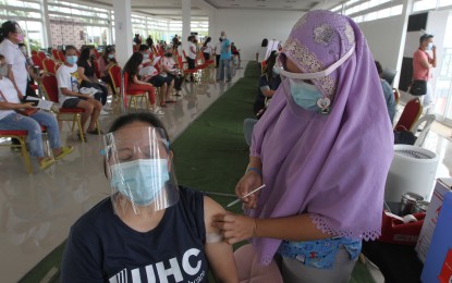 <p><strong>'ROAD TO ZERO</strong>'. A medical front-liner administers a Covid-19 vaccine to a woman at the Lakeshore vaccination hub in Taguig City on Wednesday (Aug. 4, 2021). The city aims to surpass the 8,000 jabs daily target set by the National Vaccination Operations Center. <em>(PNA photo by Avito C. Dalan)</em></p>