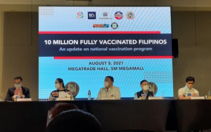 <p><strong>10 MILLION.</strong> Presidential Spokesperson Harry Roque Jr. (center) announces that 10,282,152 Filipinos are already fully vaccinated against Covid-19 during a media briefing at the SM Megamall in Mandaluyong on Thursday (Aug. 5. 2021). Roque said vaccination will continue no matter what the quarantine classification is. <em>(PNA photo by Maritz Moaje)</em></p>