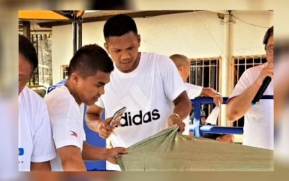 <p><strong>PRE-OLYMPICS.</strong> Carlo Paalam (left) and Eumir Marcial distribute equipment and cash aid to children and teenage boxers in Cagayan de Oro City in this October 2018 photo. Three years later, the two Mindanao natives gave the Philippines silver and bronze, respectively, at the Tokyo Olympics. <em>(PNA file photo by Nef Luczon)</em></p>