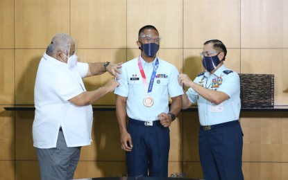 <p><strong>PROMOTED.</strong> Eumir Marcial (middle), whose rank was Airman First Class prior to the Olympics, was pinned with the sergeant chevrons by Philippine Air Force commander Lt. Gen. Allen Paredes (right) and Executive Secretary Salvador Medialdea shortly after he arrived from Japan Monday (Aug. 9, 2021). The boxer who hails from Zamboanga entered the PAF in 2013 and is organic personnel of its Civil Military Operations Group. <em>(PAF photo)</em></p>