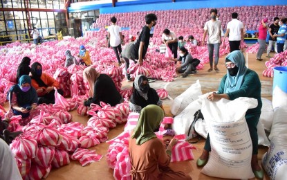 <p><strong>HELPING HAND</strong>. Muslim women who are members of Ilocos Norte United Muslim Association volunteer help repack goods intended for locked down Ilocano families in Laoag City. The City Social Welfare and Development Office on Wednesday (Aug. 11, 2021) started to distribute the food packs to indigent families who were affected by the localized enhanced community quarantine. (<em>Photo courtesy of the City Government of Laoag</em>) </p>