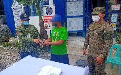 <p><strong>BACK TO THE FOLD OF LAW</strong>. A former member of the New People’s Army (NPA) in Gabaldon, Nueva Ecija voluntarily surrendered to the 91st Infantry Battalion of the Philippine Army on Tuesday (Aug. 10, 2021). The surrenderer is shown turning over a firearm and subversive documents to military authorities. <em>(Photo courtesy of 91IB)</em></p>