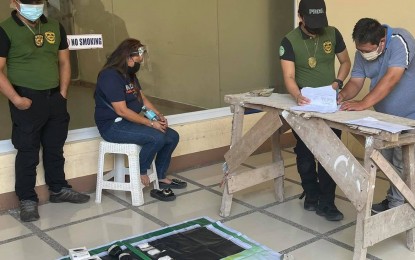 <p><strong>BUSTED.</strong> Suspect Loida Verallo (2nd from left) is arrested by agents of the Philippine Drug Enforcement Agency-Caraga in Butuan City on Saturday (Aug. 14, 2021). About 100 grams of shabu worth PHP680,000 were detected by a K9 dog inside the parcel of the suspect. <em>(Photo courtesy of PDEA-13)</em></p>