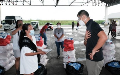 <p><strong>FOOD PACKS</strong>.  Ilocos Norte Governor Matthew Joseph Manotoc (right) personally supervises the distribution of food packs to locked down barangays of Ilocos Norte on Tuesday (Aug. 17, 2021). Since January, the Ilocos Norte government has distributed around 30,000 food packs from various donors. (<em>Photo courtesy of the Provincial Government of Ilocos Norte</em>) </p>