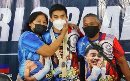 <p><strong>HOMECOMING.</strong> Tokyo Olympic boxing silver medalist Carlo Paalam (center) reunites with his parents, Jocelyn and Pio Reo, in Cagayan de Oro City on Tuesday (Aug. 24, 2021). The city government welcomed the hometown hero with a ceremony that included the handing of a PHP2-million cash incentive.<em> (Photo courtesy of Ian Fuentes/CDO-CIO)</em></p>