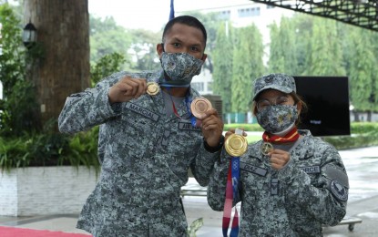 <p><strong>MILITARY AWARDS.</strong> Weightlifter Hidilyn Diaz (right) and boxer Eumir Felix Marcial show their Olympic gold and bronze medals, respectively, and the military medals they received from the Armed Forces of the Philippines during the awarding rites at Camp Aguinaldo, Quezon City on Wednesday (Aug. 25, 2021). Diaz and Marcial are members of the Philippine Air Force with the ranks of Staff Sargent and Sargent, respectively. <em>(Photo courtesy of AFP)</em></p>