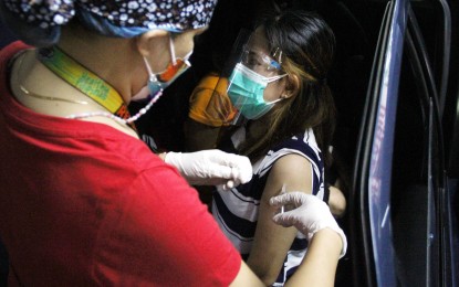 <p><strong>DRIVE-THRU JAB. </strong>A medical worker administers a Covid-19 vaccine to a motorist at a drive-thru vaccination site of a mall in Imus, Cavite on Aug. 11, 2021. Motorists can avail of drive-thru vaccination by appointment only. <em>(PNA photo by Jess M. Escaros Jr.)</em></p>