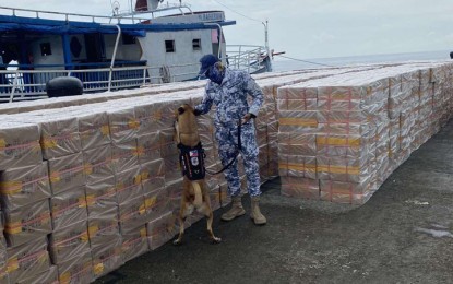 <p><strong>SMUGGLED CIGARETTES.</strong> Troops of the Naval Forces Western Mindanao (NFWM) seize on the evening of Aug. 23, 2021 some PHP29 million worth of smuggled cigarettes while on maritime security patrol 15 nautical miles southeast of Manuk Mankaw, Simunul, Tawi-Tawi. A K-9 unit of the Coast Guard District Southwestern Mindanao inspects the contraband upon arrival of the contraband for inventory at Naval Station Romulo Espaldon in Zamboanga City on Aug. 25, 2021. <em>(Photo courtesy of the NFWM Public Affairs Office)</em></p>