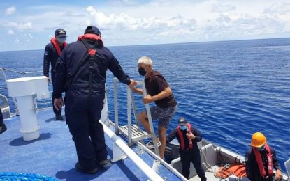 <p><strong>RESCUED.</strong> Swiss national Peter Niklaus, 71, climbs the BRP-Bagacay after his rescue on Thursday (August 26, 2021) by Philippine Coast Guard (PCG) personnel in the Sulu sea. Niklaus' yacht experienced engine trouble while he was sailing to Puerto Princesa in Palawan coming from Siaton, Negros Occidental.<em> (Photo courtesy of PCG Southeastern Mindanao District)</em></p>