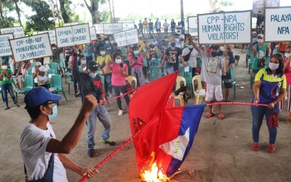 <p><strong>REJECTED</strong>. Members of two farm workers groups in Barangay E. Lopez, Silay City, Negros Occidental burn the flags of Communist Party of the Philippines-New People’s Army and the National Democratic Front in rites held at the village covered court on Saturday (Aug. 28, 2021). They also declared as persona non grata groups aiding communist-terrorists. <em>(Photo courtesy of 79th Infantry Battalion, Philippine Army)</em></p>