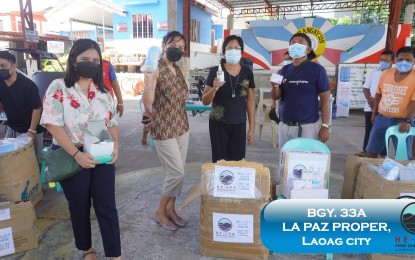 <p><strong>HEALTHCARE BOOST</strong>. Local officials and residents of Barangay 33A La Paz in Laoag City, Ilocos Norte receive healthcare packages from He Sha Company on Aug. 23, 2021. Included in the package are face masks, hand sanitizers and FDA-approved oral anti-viral spray. (<em>Photo courtesy of He Sha Prime Sand and Gravel Aggregates Philippines Inc.</em>) </p>