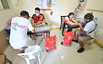 <p><strong>CASH, FOOD AID.</strong> Two porters at the Davao International Airport (DIA) sign documents acknowledging receipt of cash and rice assistance from the office of Davao City 1st District Rep. Paolo "Pulong" Duterte on Wednesday (Sept. 1, 2021). A total of 92 porters received the assistance. <em>(Photo courtesy of 1st District Rep. Paolo 'Pulong' Duterte's office)</em></p>