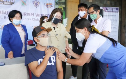 <p><strong>PROTECTED.</strong> Department of Tourism Secretary Bernadette Romulo-Puyat and National Task Force Against Covid-19 (NTF) deputy chief implementer Secretary Vince Dizon witness the inoculation of tourism workers in Baguio City. About 7,510 tourism workers in the city have been vaccinated against the coronavirus, exceeding the target of almost 6,000 workers. <em>(Photo courtesy of DOT)</em></p>