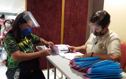 <p><strong>RISK ALLOWANCE</strong>. A health worker (left) receives her Special Risk Allowance as ordered by President Rodrigo Duterte, in a mall in Zamboanga City on Tuesday (Aug. 31, 2021). About 200 health workers who directly catered to Covid-19 patients in this city received theirs from the Department of Health, through the city government. <em>(Photo courtesy of the City Hall Public Information Office)</em></p>