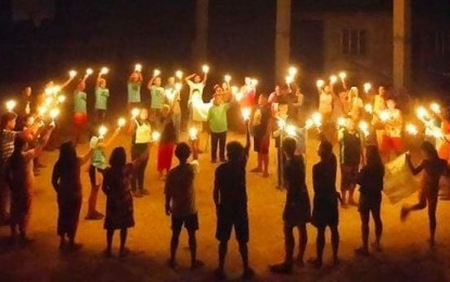 <p><strong>CALL FOR JUSTICE.</strong> Residents of Inopacan, Leyte join a candle-lighting activity at the town plaza on Aug. 28, 2021. It has been 15 years since the discovery of the remains of some of the victims of a massacre perpetrated by the New People’s Army in the 1980s. <em>(Photo courtesy of Philippine Army)</em></p>