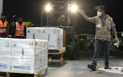 <p><strong>MORE LIFE-SAVING DOSES.</strong> A Department of Health staff guides the forklift operator carrying the boxes of newly arrived Pfizer vaccine acquired through the COVAX Facility at the NAIA Terminal 3 in Pasay City on Thursday (Sept. 2, 2021). The government is expecting the delivery of about 10 million Pfizer vaccine doses for the remaining months of this year. <em>(PNA photo by Robert Oswald P. Alfiler)</em></p>