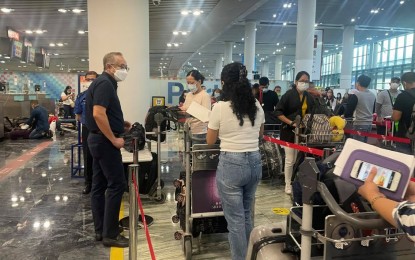 <p><strong>GOING HOME.</strong> Consul General Porfirio Mayo Jr. (left) addresses queries from passengers checking-in at the airport in Macau. The latest repatriation flight brought to over 4,000 the number of Filipinos flown home from Macau. <em>(Photo courtesy of DFA)</em></p>